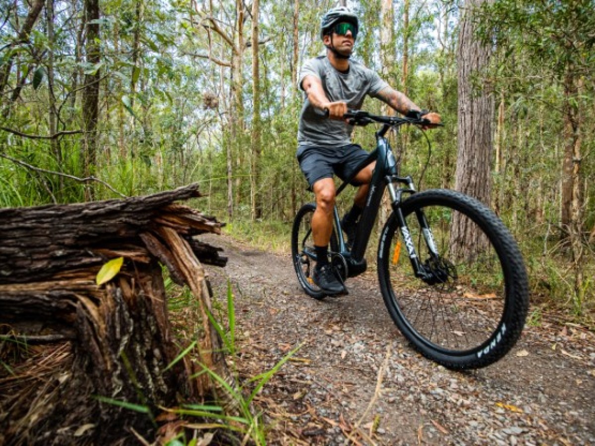 a man riding a bike down a dirt road