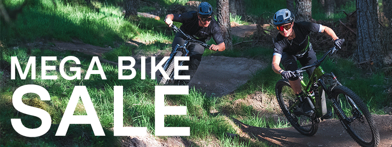 a man riding a bike down a dirt road