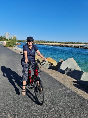 Tracey riding a e-bicycle Pt Cartwright Rock Wall