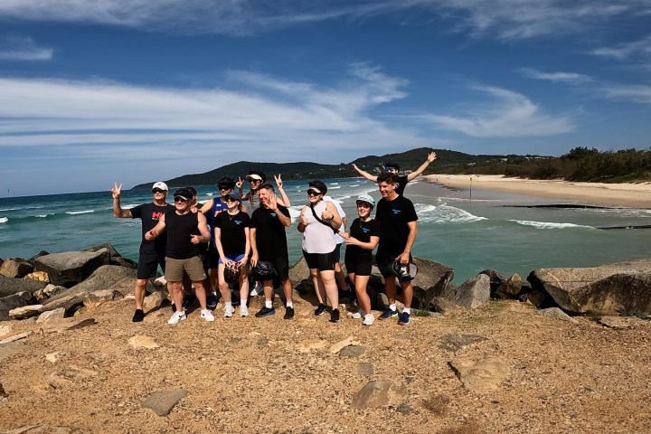 Group of 10 e-bike riders at Noosa Heads overlooking Laguna Bay and Noosa Main Beach