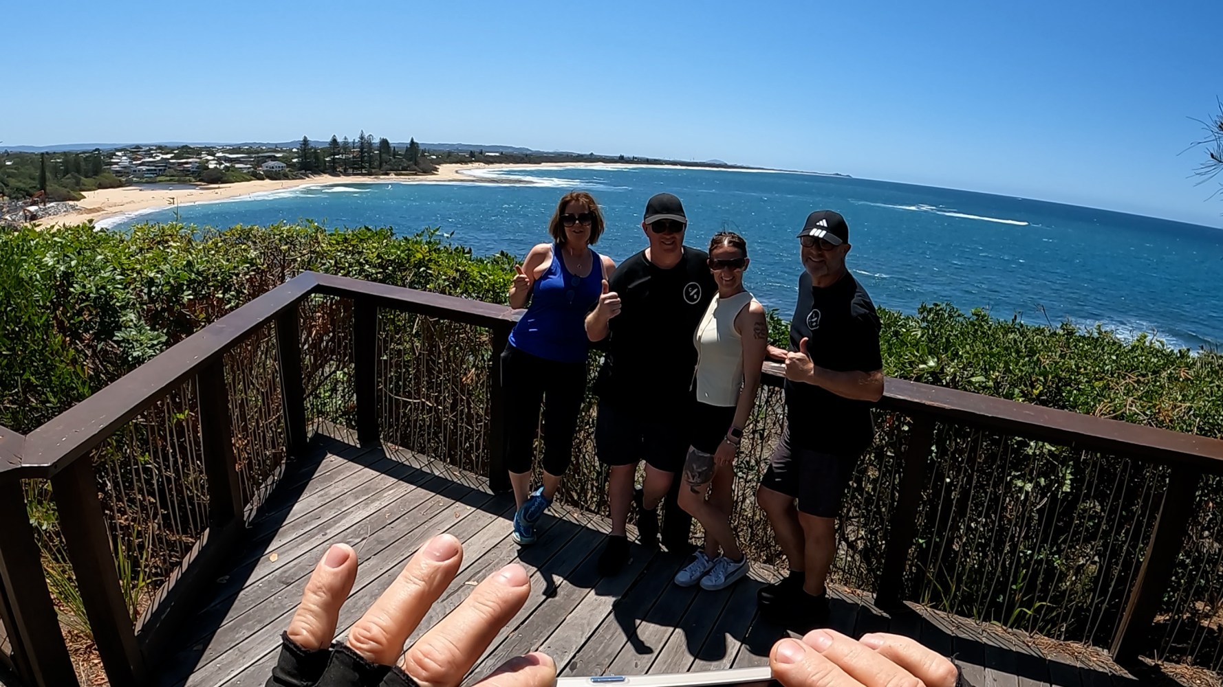 Stuart Whitney taking a photo of four happy ecoTekkSC riders at Queen of Colonies Lookout, Moffat Beach